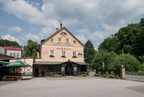 a large building with a sign on top of it at Pension Herman in Rudník