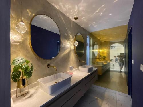 a bathroom with two sinks and two mirrors at Hub Hua Hin 57 in Hua Hin