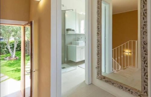 a mirror in a hallway with a bathroom at Torretta con vista mozzafiato in Chia