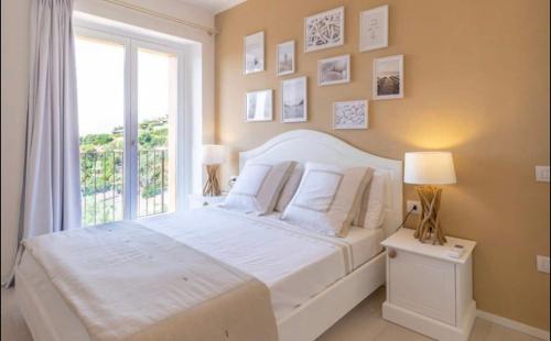 a bedroom with a large white bed and a window at Torretta con vista mozzafiato in Chia
