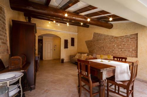 a dining room with a table and chairs and a brick wall at Grace apartment - Smart Holiday in Mantova
