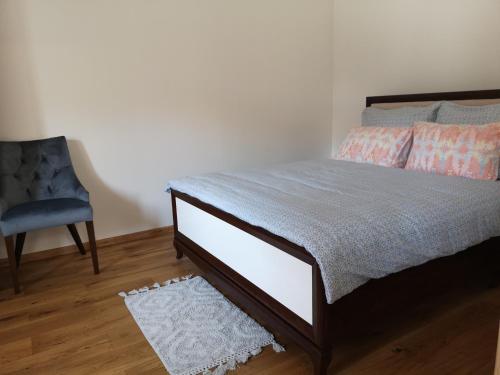 a bedroom with a bed and a blue chair at Apartament Zielony in Włodawa