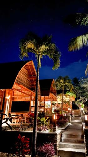 a building with a palm tree in front of it at Griyatama Bungalow in Nusa Penida