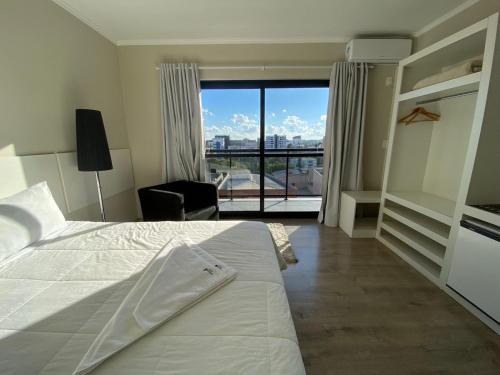 1 dormitorio con cama y vistas a la ciudad en Hayer Hotel, en Erechim