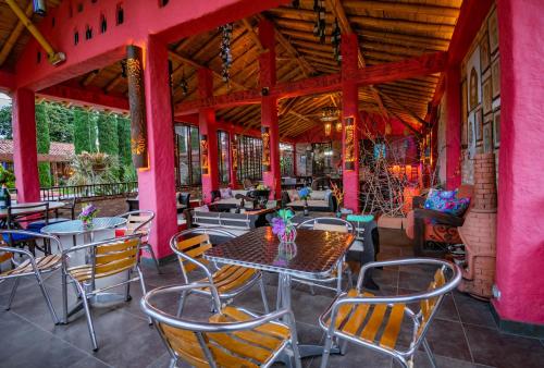 a patio with tables and chairs in a restaurant at Hotel Campestre Solar De La Luna in Armenia