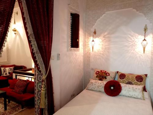 - une chambre avec un lit doté d'un oreiller rouge dans l'établissement Dar Azahara, à Fès
