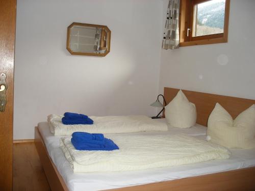 two beds in a room with blue pillows on them at Haus Ausserbach in Gaschurn