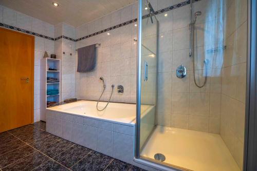 een badkamer met een bad en een glazen douche bij Ferienwohnung Schötz in Moosbach