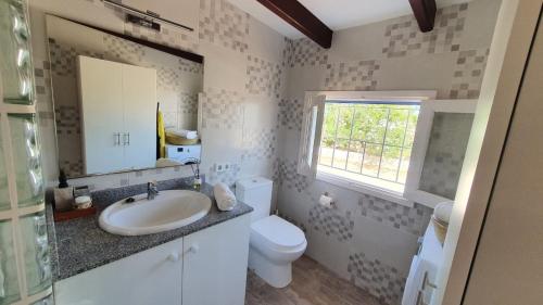uma casa de banho com um lavatório, um WC e uma janela. em CA NA CATALINA DEN ANDREU em Sant Francesc Xavier