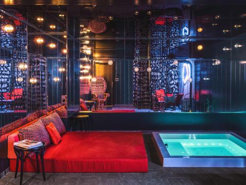 a room with a couch and a hot tub at Chouchou Hotel in Paris