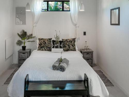 una camera da letto con un grande letto bianco con panca di Villa Palmera Load shedding FREE a Mossel Bay