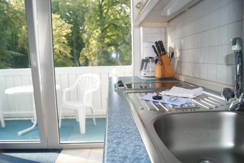 een keuken met een wastafel, een tafel en een raam bij Residenz Seeblick in Ostseebad Sellin