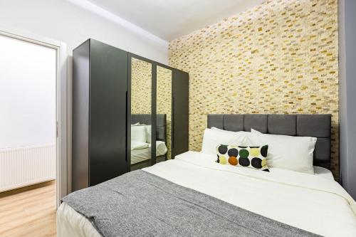 - une chambre avec un grand lit et un mur en briques dans l'établissement Flat with Backyard in Sisli, à Istanbul