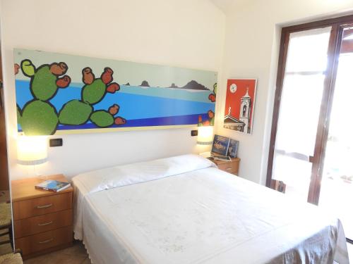 1 dormitorio con 1 cama y una pintura en la pared en Casa Navarra, en Santa Maria Navarrese