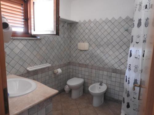 y baño con aseo y lavamanos. en Casa Navarra, en Santa Maria Navarrese