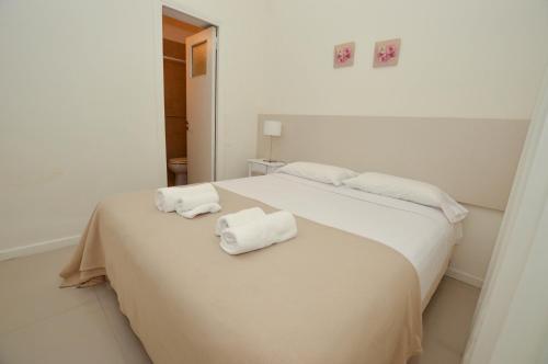 1 dormitorio blanco con 2 toallas en una cama en Hotel Acqua en Mar del Plata