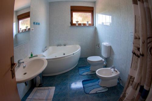 a bathroom with a tub and a toilet and a sink at House /Villa Maja in Ližnjan