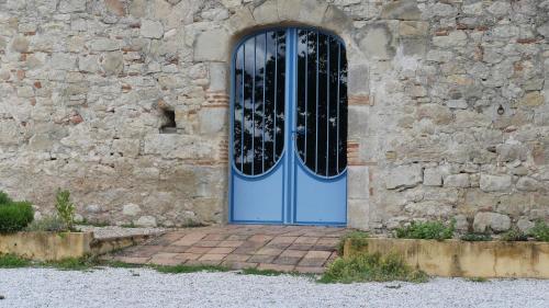 a blue door in a stone building with a window at Ferme fortifiée du 18e rénovée avec vue in Lacroisille