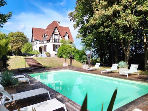 a swimming pool in front of a house at Villa avec vue et piscine à moins d'1h de Paris in Rolleboise