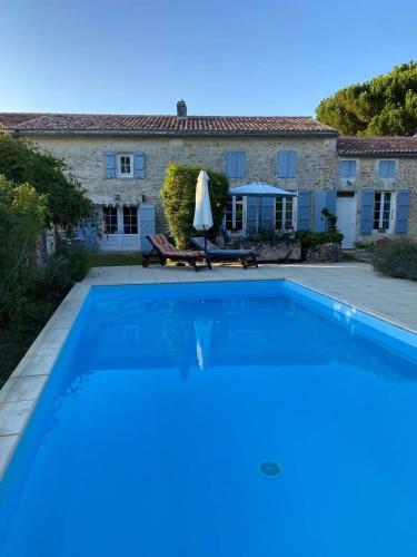 une grande piscine devant une maison dans l'établissement Gîte Rochellier - Charente-Maritime, à Cravans