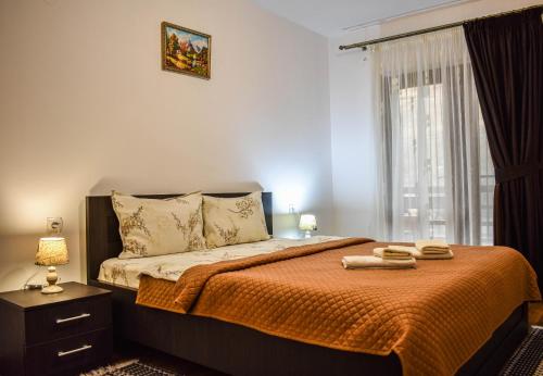 a bedroom with a bed with two towels on it at Pensiunea Bucur in Dămuc
