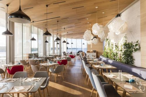 a restaurant with tables and chairs and large windows at D-Resort Šibenik in Šibenik
