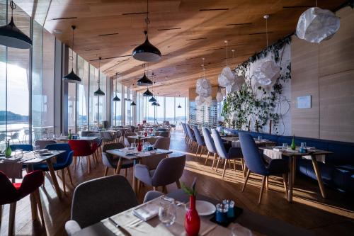 a restaurant with tables and chairs in a room with windows at D-Resort Šibenik in Šibenik
