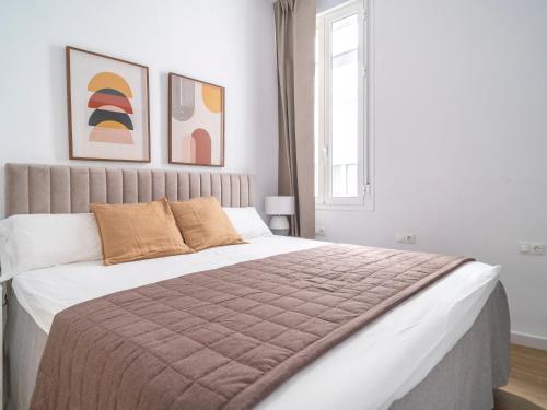 1 dormitorio con 1 cama grande en una habitación blanca en Sanders Lavender - Delightful Two-Bedroom Apartment Downtown, en Málaga