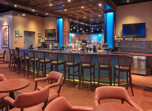 a bar in a restaurant with chairs and tables at Holiday Inn Blytheville, an IHG Hotel in Blytheville