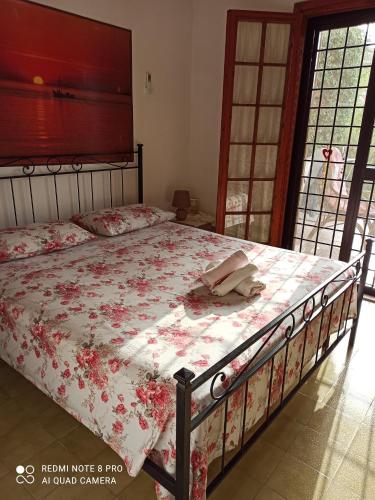 サバウディアにあるVillino Vuociのベッドルーム1室(花柄の掛け布団付きのベッド1台付)
