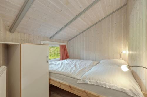 a bed in a small room with a window at Kranich Ferienhäuser mit Innenpool in Hohendorf