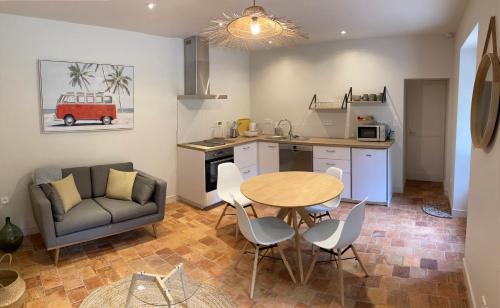 une cuisine et un salon avec une table et un canapé dans l'établissement Les Bosquets, à Saint-Ouen-des-Toits