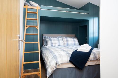 a bunk bed with a ladder in a bedroom at Shiphorns luxury cabin with a hot tub in Eddleston