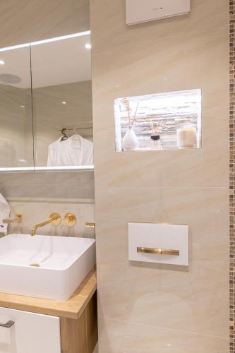 a bathroom with a white sink and a mirror at Sunset Home, Appartement de luxe front de lac in Veytaux