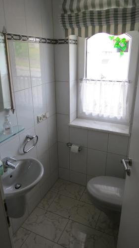 a bathroom with a sink and a toilet and a window at Villa Hardegsen in Hardegsen