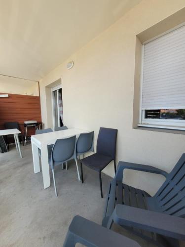 une pièce avec une table, des chaises et une fenêtre dans l'établissement Vacances détente, à Argelès-sur-Mer