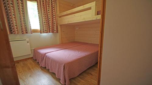 een kleine slaapkamer met een bed in een kamer bij Les Chalets du Parc aux Etoiles - Cimes et Neige in Puy-Saint-Vincent