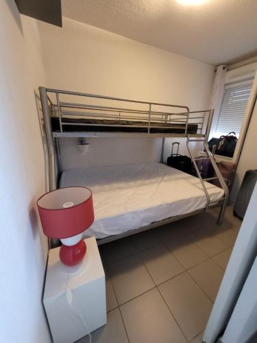 - une chambre avec des lits superposés et une lampe rouge dans l'établissement Vacances détente, à Argelès-sur-Mer