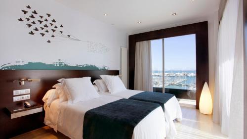 a bedroom with a large bed and a large window at Hotel Costa Azul in Palma de Mallorca