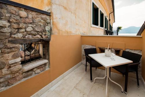 a table and chairs in a restaurant with a stone wall at Hotel Del Porto in Torri del Benaco