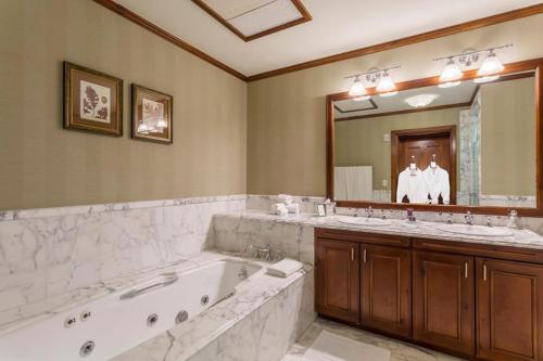 a bathroom with two sinks and a tub and a large mirror at Aspen Ritz-carlton 2 Bedroom Ski In, Ski Out Residence With Access To Slopeside Heated Pools And Hot Tubs in Aspen