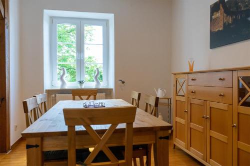 comedor con mesa de madera y sillas en Ferienhaus Reuter, en Schweich