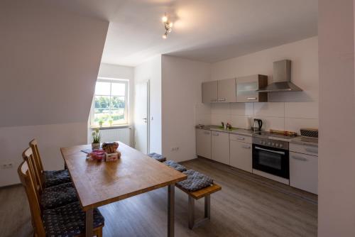 eine Küche mit Holztisch und ein Esszimmer in der Unterkunft Gästehaus Olympia Wilhelmshaven - Moderne Einzelzimmer mit eigenem Bad für Monteure in Schortens