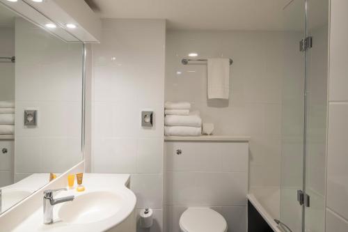 a white bathroom with a sink and a toilet at Crowne Plaza Plymouth by IHG in Plymouth