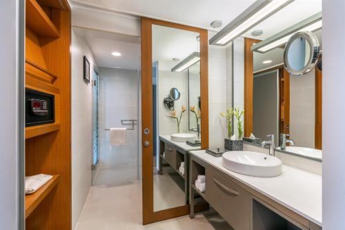 a bathroom with two sinks and a large mirror at Vivanta Ahmedabad SG Highway in Ahmedabad