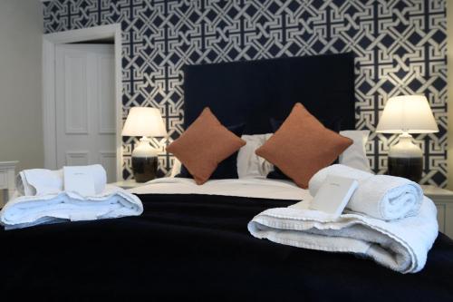 um quarto com uma cama grande e toalhas em The Victoria Hotel em Bamburgh