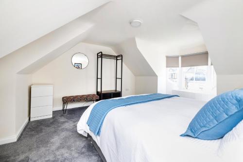 a white bedroom with a large bed and a window at 2 bedroom apartment on Peebles High Street in Peebles