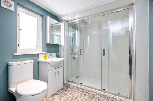 a bathroom with a shower and a toilet and a sink at 2 bedroom apartment on Peebles High Street in Peebles
