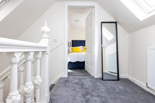 a hallway with a mirror and a bed in a room at 2 bedroom apartment on Peebles High Street in Peebles