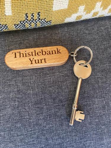 a wooden keychain with a sign that readsinkaawk vault at Thistlebank Yurt in Llangollen